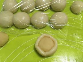 包裹上油酥皮材料，放在手的虎口位置，一点点推揉面团，将油酥皮包裹上，捏紧收口，做好后继续盖保鲜膜