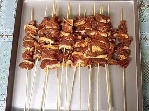 用事先备好竹签、将腌好的羊肉肥瘦相间一一串起来