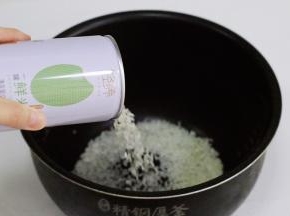 把大米倒入电饭煲锅内。