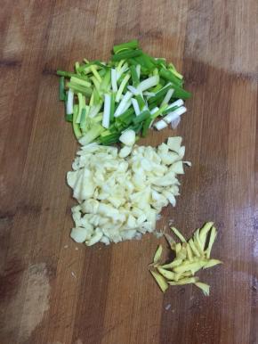蒜瓣剁碎，小葱切成段儿，生姜切成条儿备用。