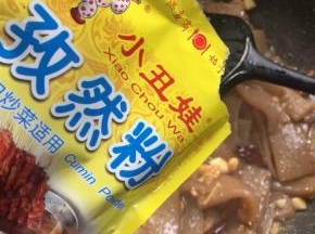 放入2勺小丑娃孜然粉翻拌均匀。