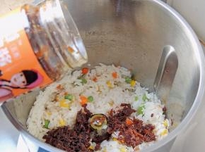 将牛肉酱倒入米饭中，选择L档继续翻炒2分钟。