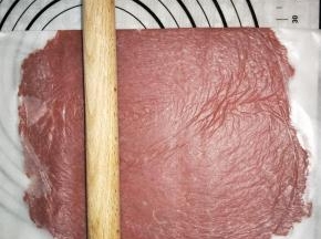 底下铺一张油纸，放上肉馅，上面覆盖一张保鲜膜，擀薄