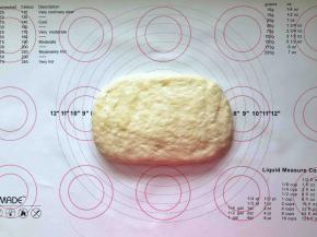 6、手上抹少许油轻轻拍开面团。