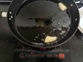 11、锅内倒入足量的油烧热，丢下一块面团，几秒内就能快速浮起，这时的油温就可以开始炸油条了。