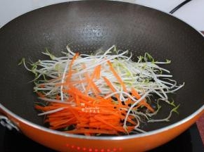 锅中少许油，倒入胡萝卜丝、豆芽；先放豆芽和胡萝卜，能让河粉暂时不接触到锅底，这样河粉就不会粘锅。