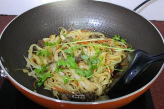 加入牛肉、生抽一起翻炒熟，筷子和锅铲要同时使用，把河粉炒至油亮干香放盐、香菜炒均即可，香喷喷，油亮干香，好吃极了。