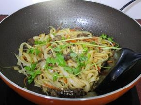 加入牛肉、生抽一起翻炒熟，筷子和锅铲要同时使用，把河粉炒至油亮干香放盐、香菜炒均即可，香喷喷，油亮干香，好吃极了。