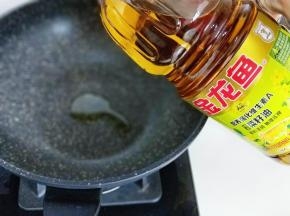 锅中加入金龙鱼强化维生素A菜籽油。