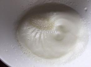 待蛋清糊搅打至蛋糊蓬松，有明显线路再加入三分之一白砂糖