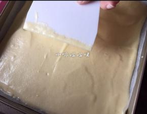 用刮板将面糊表面刮平，将烤盘提起至距离桌面5厘米高度敲摔出起泡