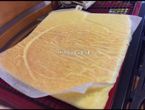 即刻翻转片状蛋糕，趁热将烘焙纸撕下，盖在蛋糕上，以免蛋糕风干