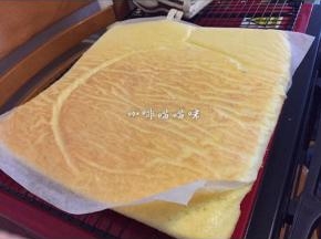 即刻翻转片状蛋糕，趁热将烘焙纸撕下，盖在蛋糕上，以免蛋糕风干