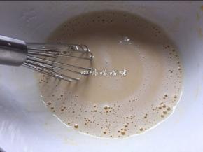 将沸腾豆浆倒入步骤21中的蛋黄中，边倒边用蛋抽搅打均匀