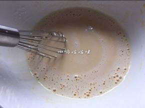 将沸腾豆浆倒入步骤21中的蛋黄中，边倒边用蛋抽搅打均匀