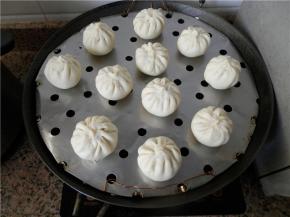 逐个包好，锅里放冷水，包子生胚排好在抹了油的蒸架上，生胚中间留些空隙，盖上锅盖，静置饧发（冬天：锅里放温水）。
