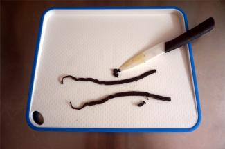 把香草荚剖开，刮出香草籽。