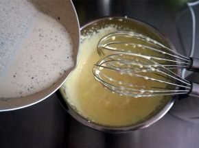 少量多次加入温热的香草牛奶，边加入边搅拌。