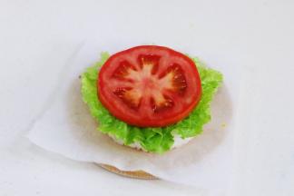 给煎好的米饭挤上番茄酱，放上一片生菜叶和西红柿片。