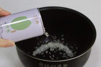 打开一罐（206克）稻花香米，倒入电饭锅内。