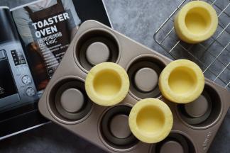 烘烤结束，将蛋糕取出，在桌面上震出热气，然后倒扣在晾架上冷却，待冷却后再震出蛋糕杯