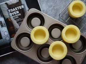 烘烤结束，将蛋糕取出，在桌面上震出热气，然后倒扣在晾架上冷却，待冷却后再震出蛋糕杯