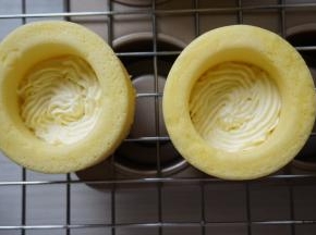 将打发好的淡奶油装入裱花袋里，挤入蛋糕杯内