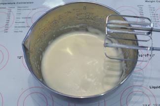 将装有鸡蛋液的打蛋盆隔温水打发至粘稠。