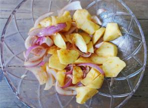 取一个大碗，把土豆块，洋葱丝放入，倒入奥尔良腌料，孜然粉，食用油混合均匀哦，腌制5分钟差不多