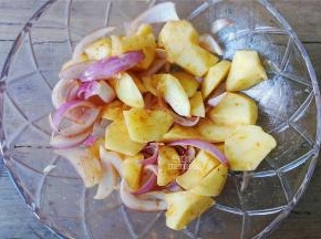 取一个大碗，把土豆块，洋葱丝放入，倒入奥尔良腌料，孜然粉，食用油混合均匀哦，腌制5分钟差不多