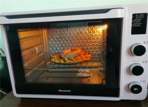 然后把腌制好的洋葱丝放入中间，再把圆肠放入上面，倒入烤箱中层继续200度烤制20分钟