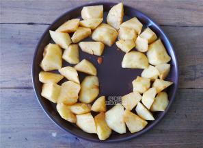 备一个圆烤盘，先把土豆块拿出来摆放上周边，烤箱预热200度，先烤制10分钟再拿出来