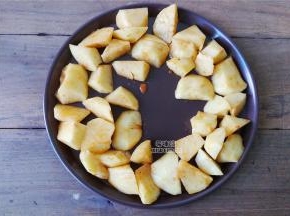 备一个圆烤盘，先把土豆块拿出来摆放上周边，烤箱预热200度，先烤制10分钟再拿出来