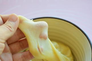 将水油皮的食材放入一个容器中，缓慢加温水，边加边搅拌，再揉成面团，放在案板上，多揉一会儿，揉出手套膜，盖上保鲜膜静置30分钟