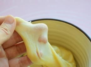 将水油皮的食材放入一个容器中，缓慢加温水，边加边搅拌，再揉成面团，放在案板上，多揉一会儿，揉出手套膜，盖上保鲜膜静置30分钟