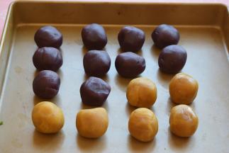 把紫薯馅分成每个25克的小圆球，紫薯馅不够了，就加点莲蓉馅，一共是16个