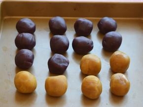 把紫薯馅分成每个25克的小圆球，紫薯馅不够了，就加点莲蓉馅，一共是16个