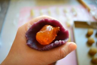 把每个紫薯馅按扁，把蛋黄放中间，利用虎口，往上捏，最后收口，备用