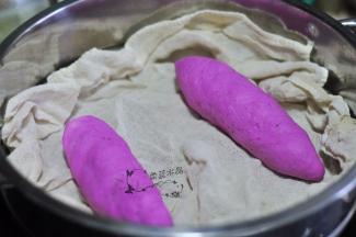 用面片完全把香肠包裹住，捏紧收口，放入蒸笼中。