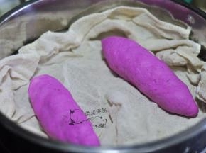 用面片完全把香肠包裹住，捏紧收口，放入蒸笼中。