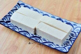 将豆腐切成条状，摆在盘中。