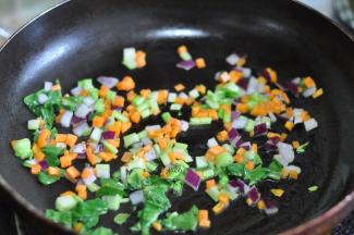 锅里倒入油，将胡萝卜丁、洋葱丁、切碎的菜心放入锅中。