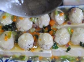 豆腐取出，按住表面，倒掉盘里的水，将勾好的芡料浇在表面。