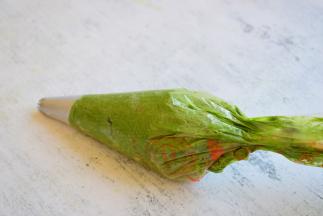 再装裱花袋，装裱花袋之前，要把裱花嘴放进裱花袋中，装完后，在裱花袋底部剪一个小孔