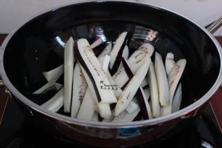 要用炒锅，热锅，倒油，大火煸炒五成熟，捞出，喜欢油多些的，可以油炸茄子五成熟捞出，控干油。