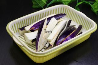 茄子用清水洗净，切大长条，用盐水浸泡3分钟，捞出沥干水，茄子用盐水浸泡之后可以让茄子颜色更加鲜艳，不变黑。