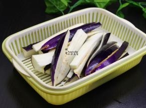 茄子用清水洗净，切大长条，用盐水浸泡3分钟，捞出沥干水，茄子用盐水浸泡之后可以让茄子颜色更加鲜艳，不变黑。