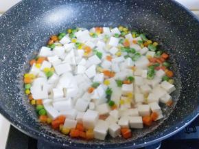 将切好的豆腐倒入什锦菜的锅中。