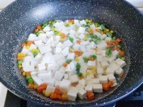 将切好的豆腐倒入什锦菜的锅中。