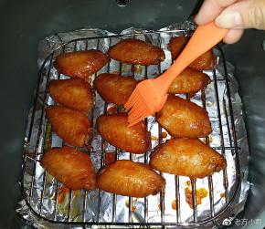 过8分钟后再取出，看颜色已明显变深了，此时翻面刷层蜂蜜水 

（PS：刷蜂蜜水让烤好的鸡翅表面透亮微甜更好吃、当然不刷也是可以的）